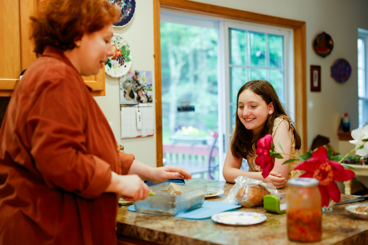 A mother and daughter preparing food in their kitchen