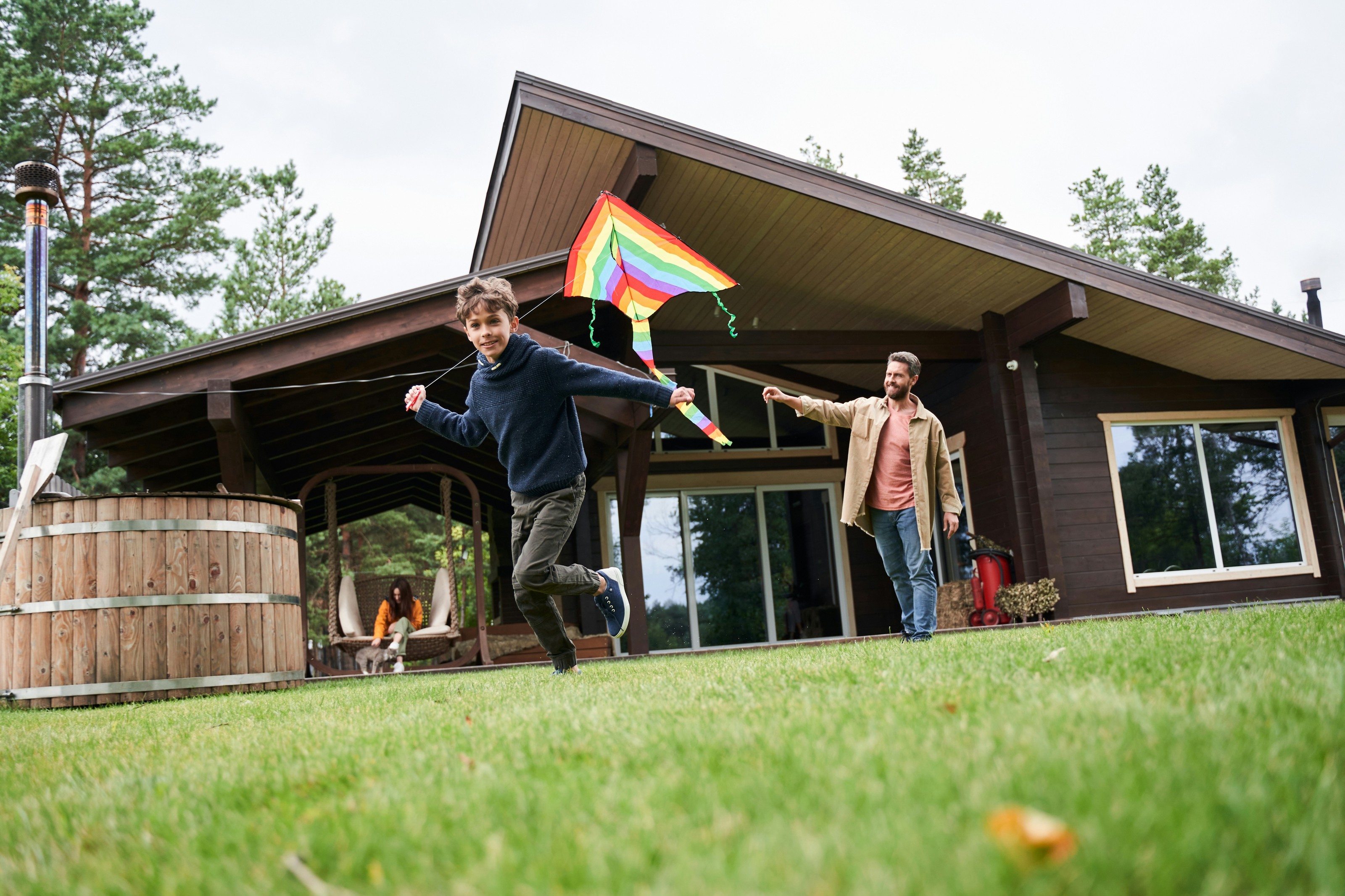 A family flying a kite in the front yard of their home
