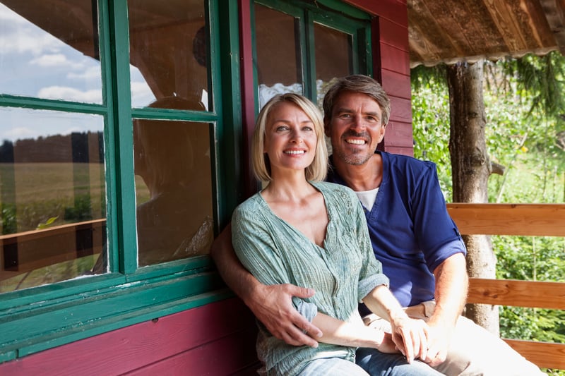 A couple sitting together on the porch of their home