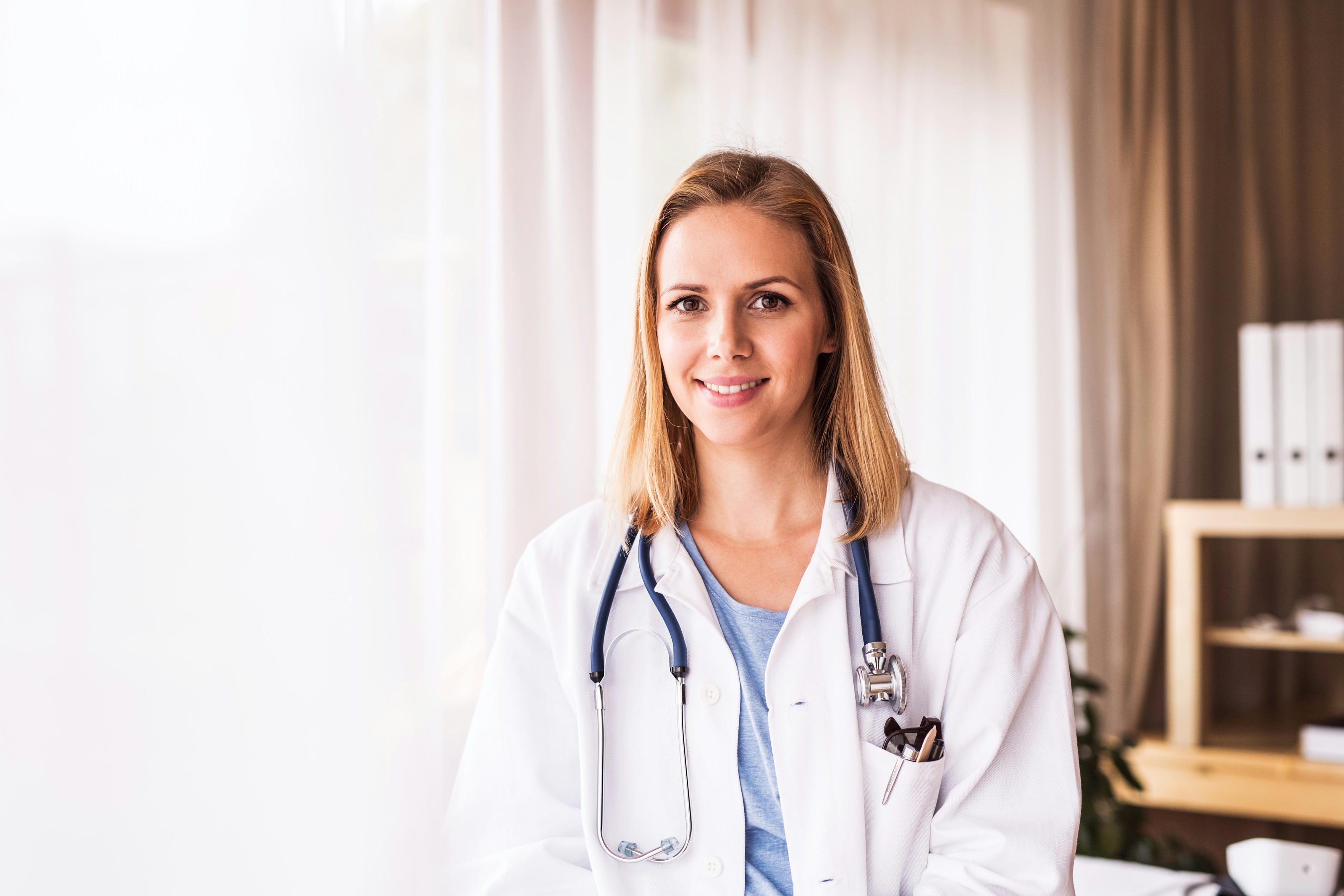 A smiling doctor in a white coat with a stethoscope