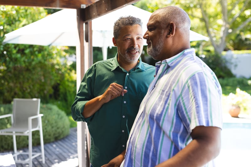 Two men talking on a backyard patio