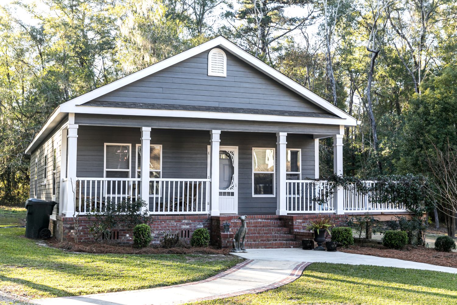 A gray single-story house with a white front porch