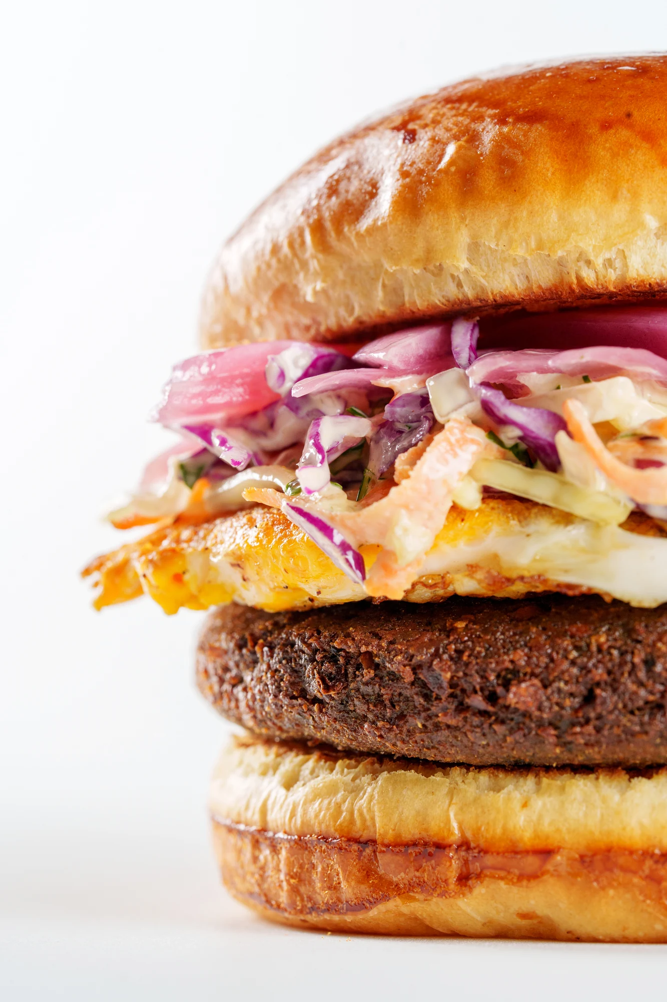 Detalhe de burger do Bullguer, com textura do pão e ingredientes em destaque.