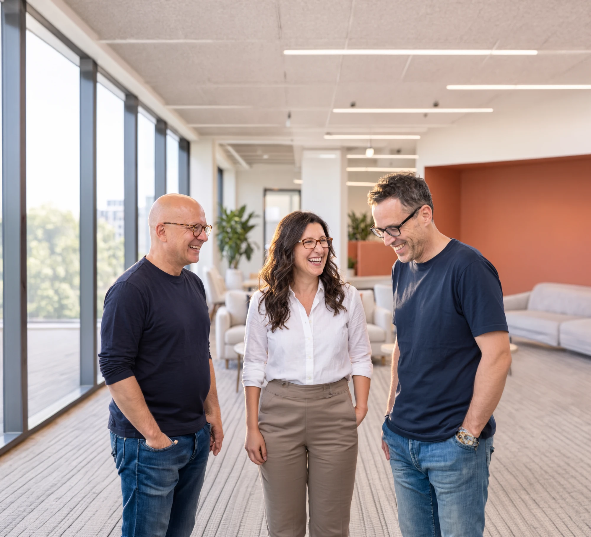 The three Synthrics co-founders laughing together in an office