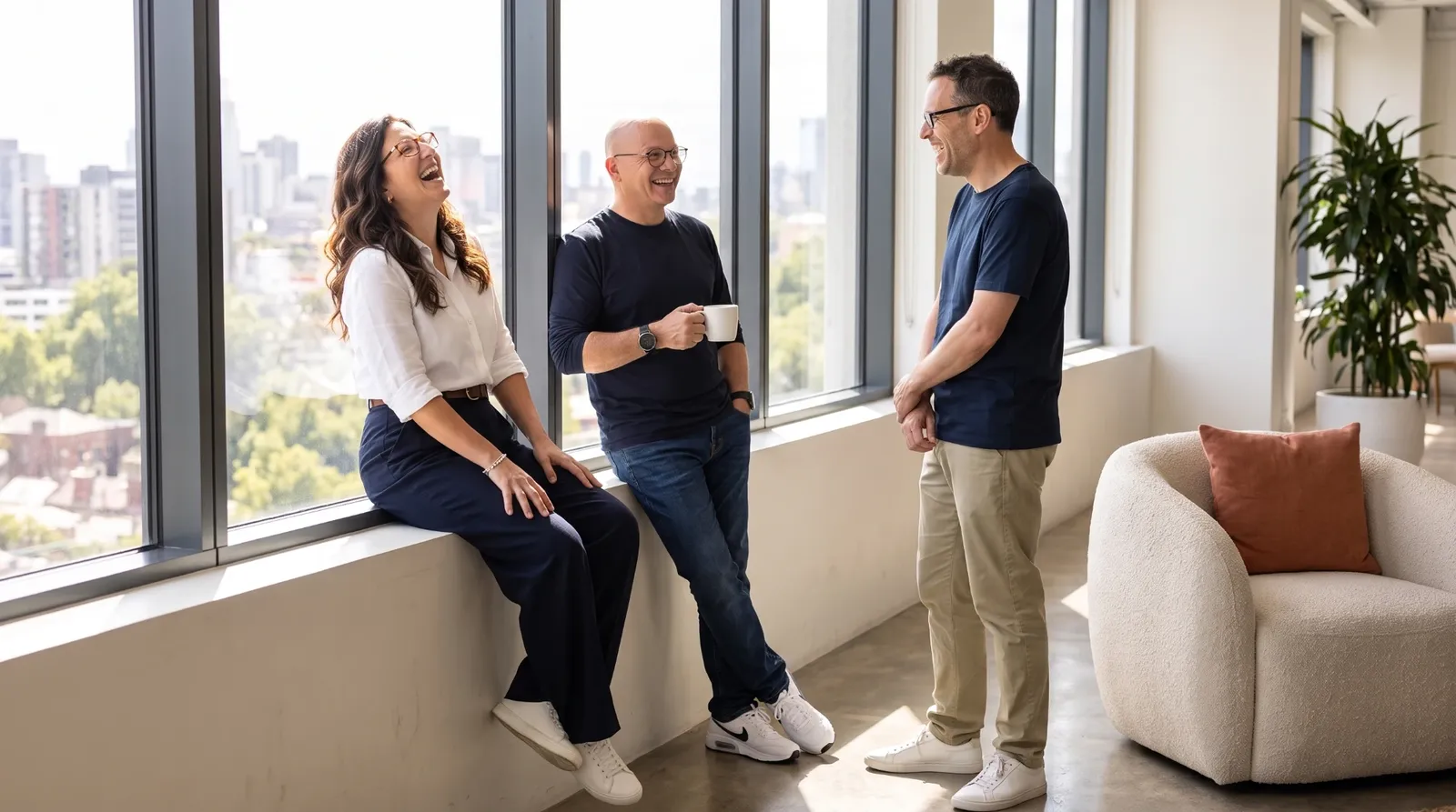 The Synthrics founders chatting and laughing by the office windows
