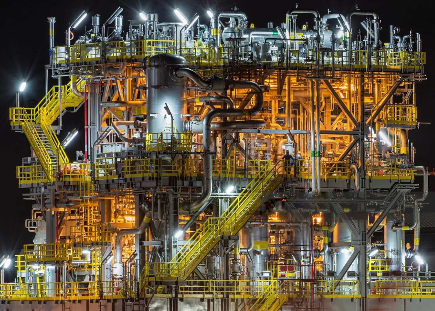 Process plant structure with stairways and pipework lit at night