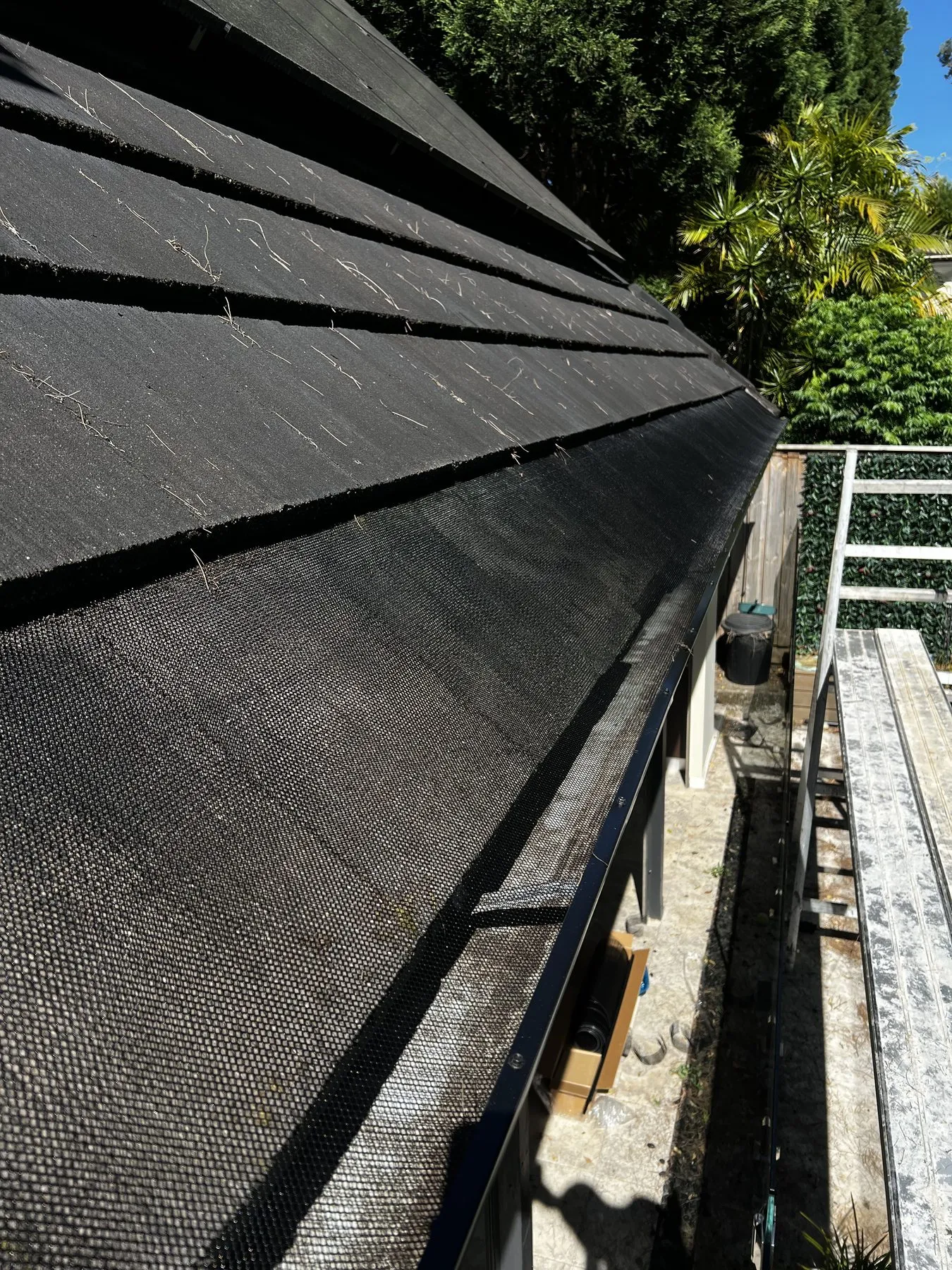 Black gutter guard detail along a tiled roof