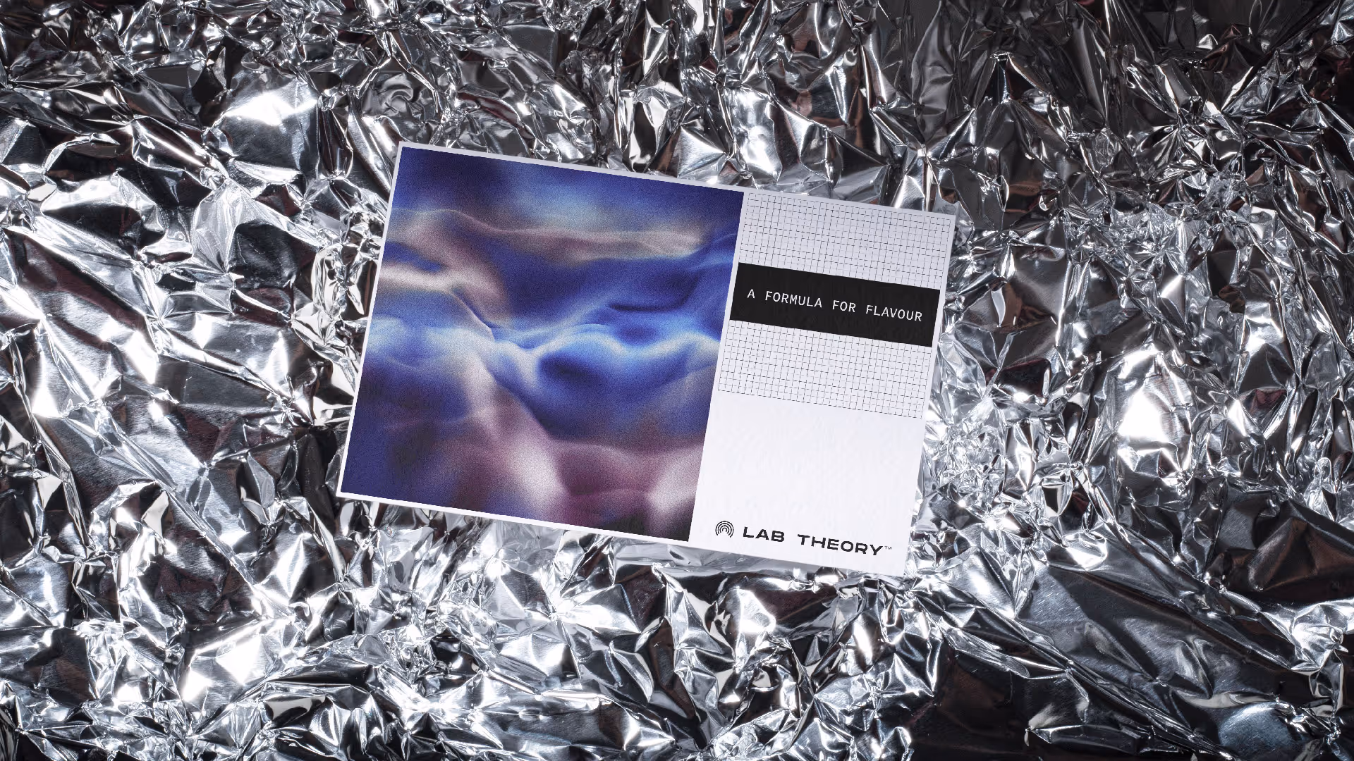 A card with a blue and purple abstract design reading 'A FORMULA FOR FLAVOUR' and 'LAB THEORY' on crinkled silver foil.