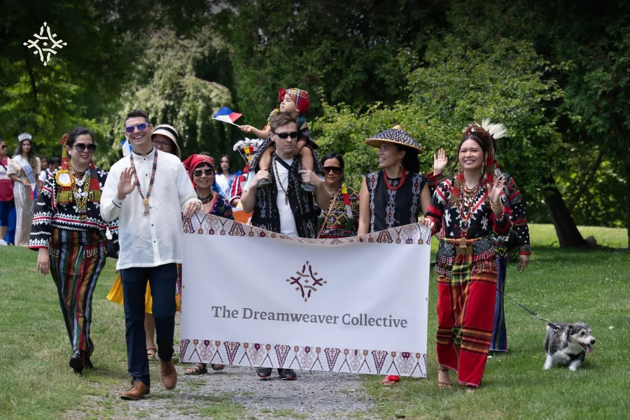 The Collective walking in a parade behind The Dreamweaver Collective banner, in Tboli and Filipino dress