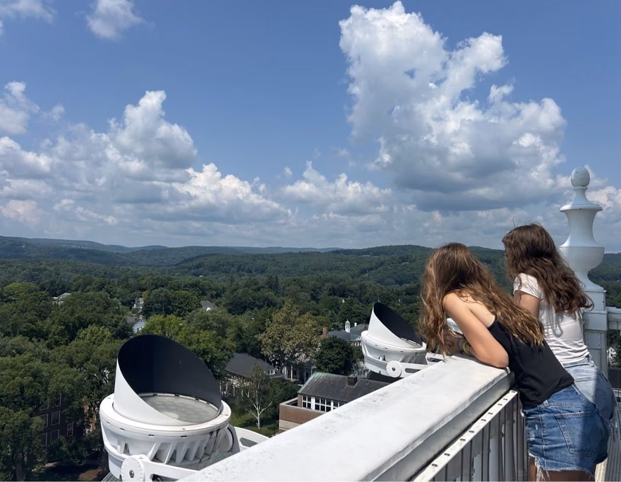 Students looking out over Hanover and the hills from a campus rooftop