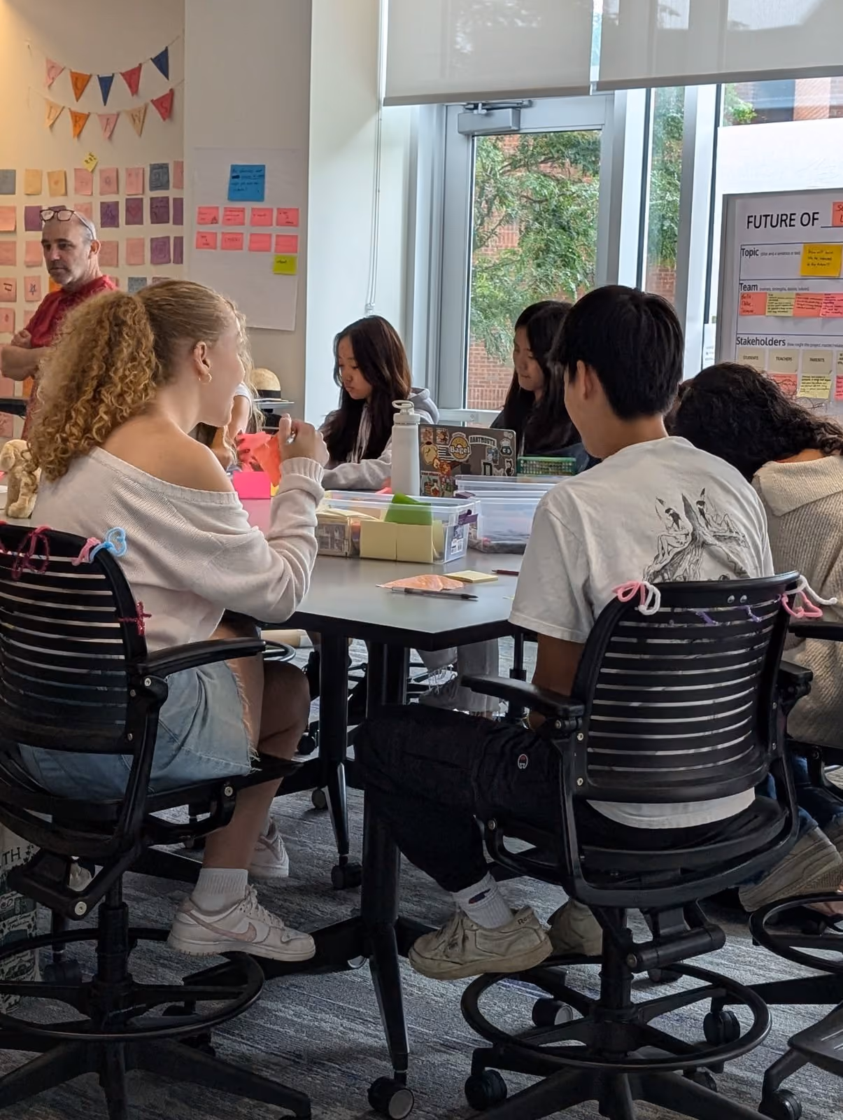 Students working at a seminar table with an instructor