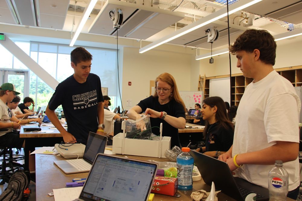 An instructor and students testing a prototype in the design studio