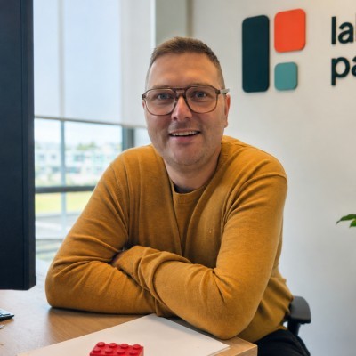 Sander van Doorn in a mustard sweater and glasses, seated at a desk in the Lakehouse Partners office.