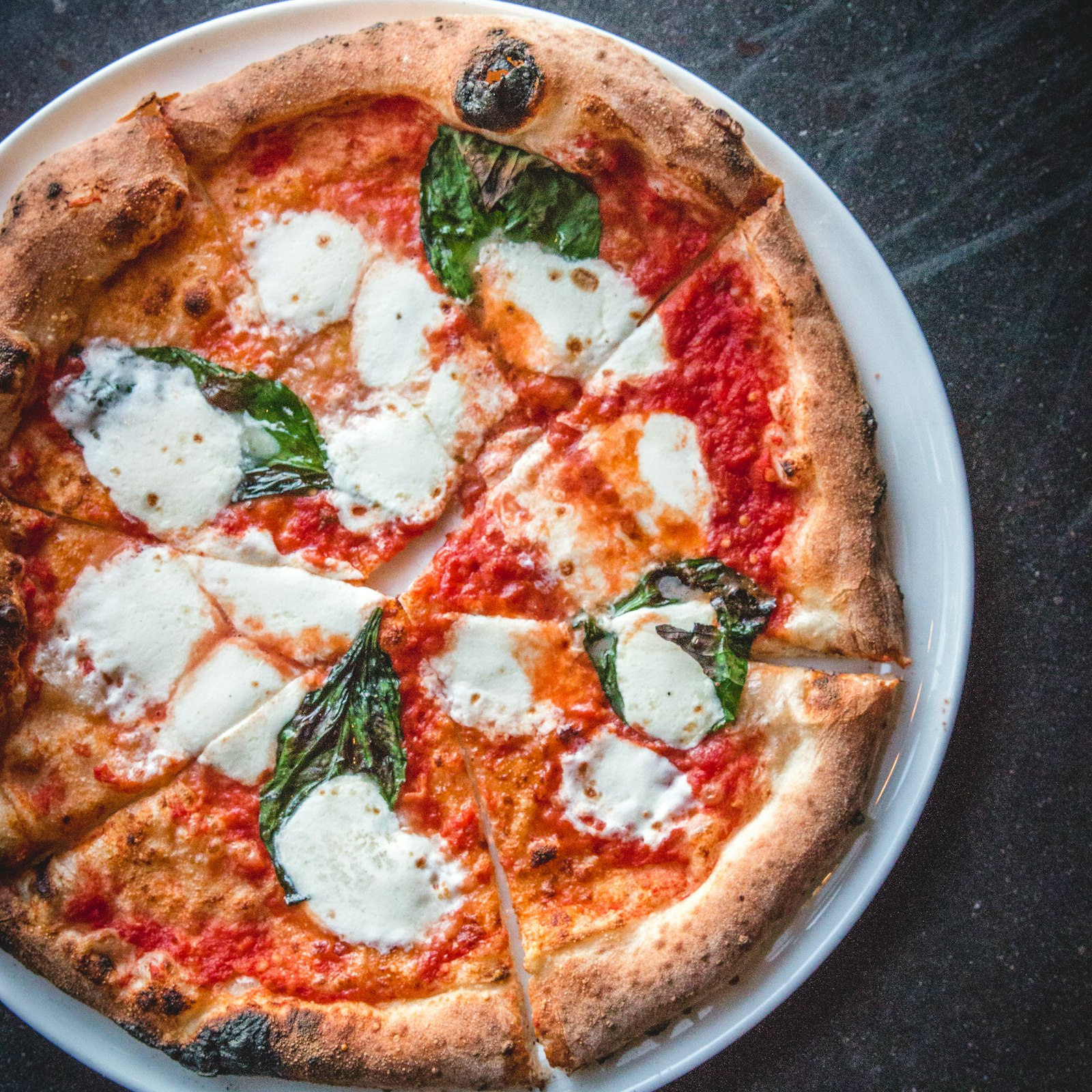 Close-up van een pizza met een geblakerde, luchtige rand