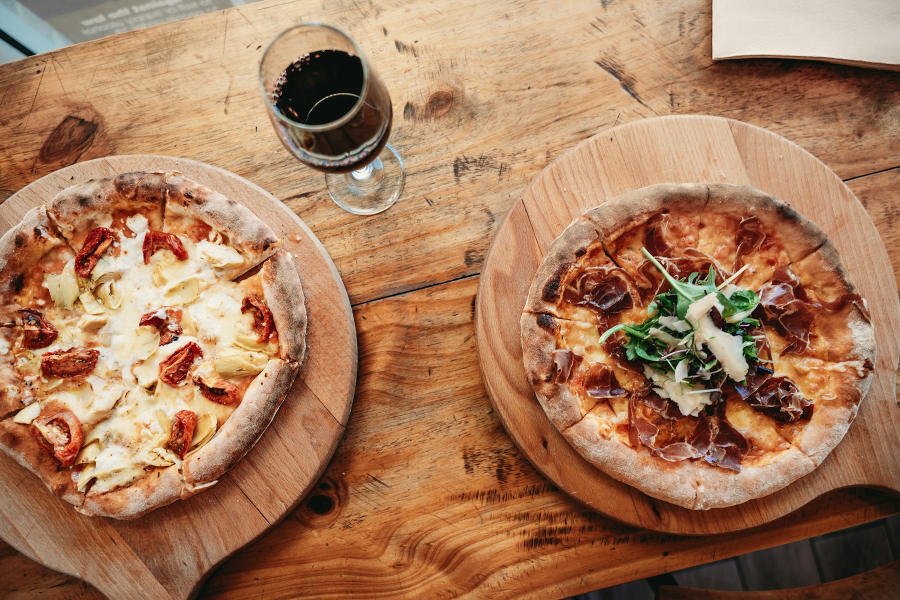 Handen die pizzapunten delen aan een warm gedekte tafel