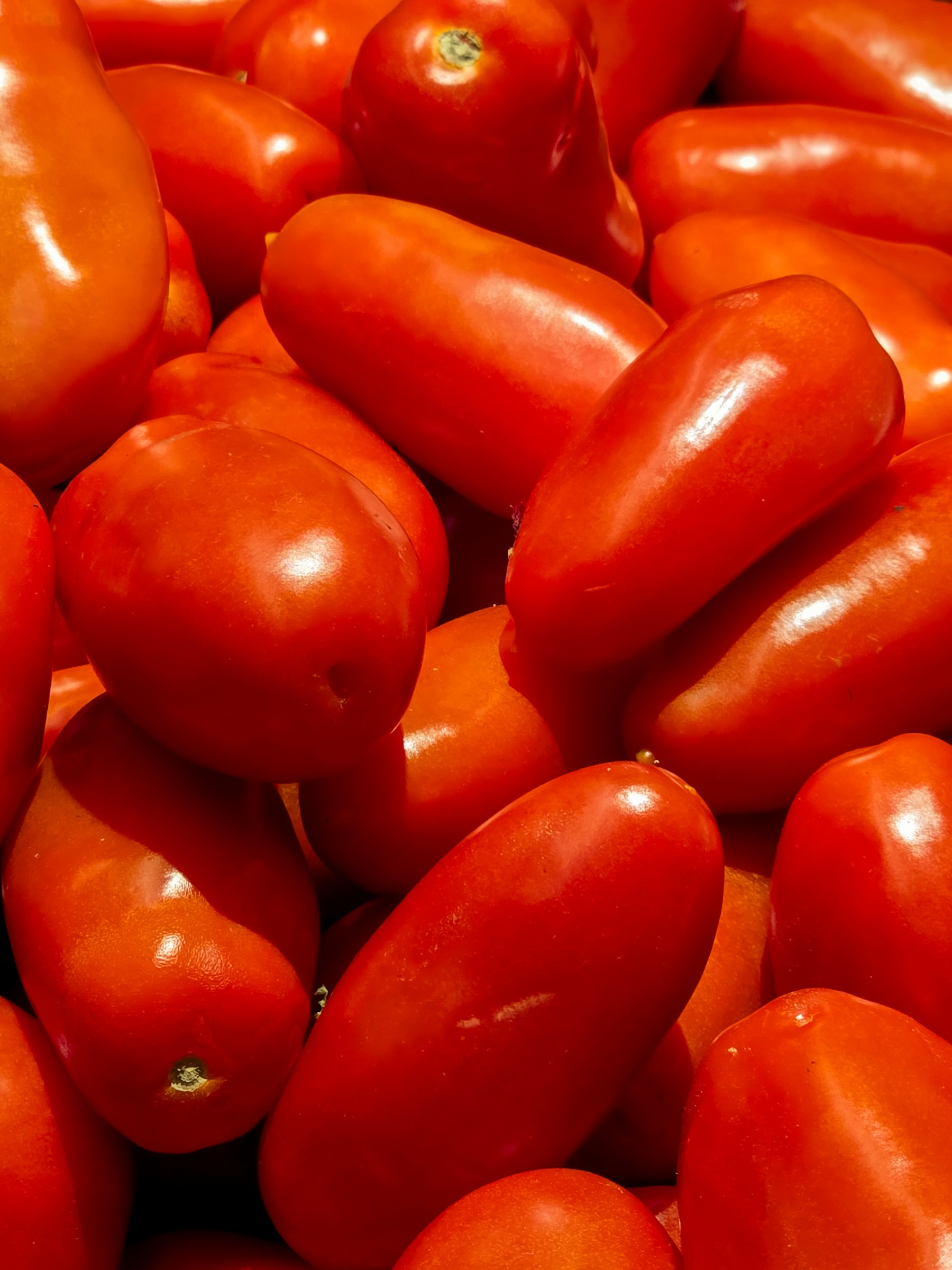 Rijpe tomaten en een fles olijfolie op een tafel