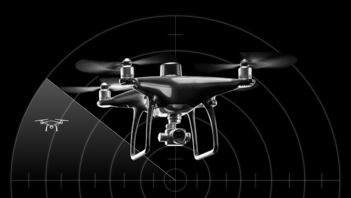 Black quadcopter drone with a camera, shown in front of a radar screen indicating drone detection.