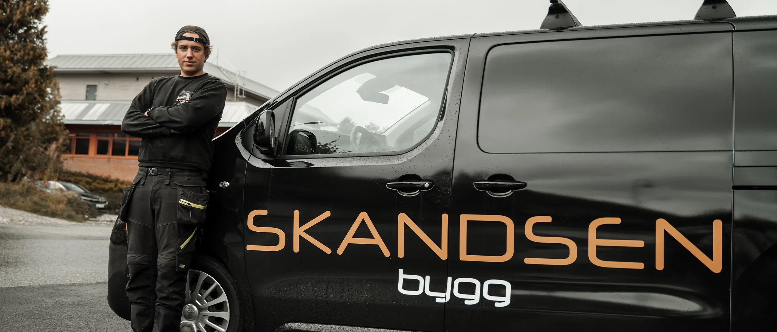 Skandsen Bygg-bil med en av tømrerne