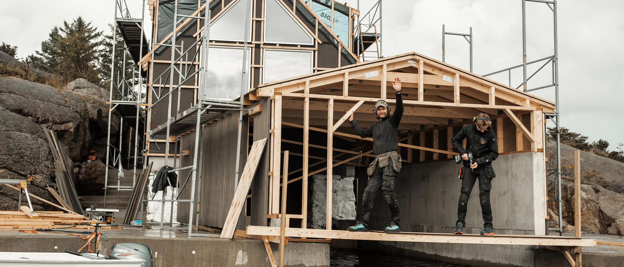 Moderne hytte med store vinduer ved vannet