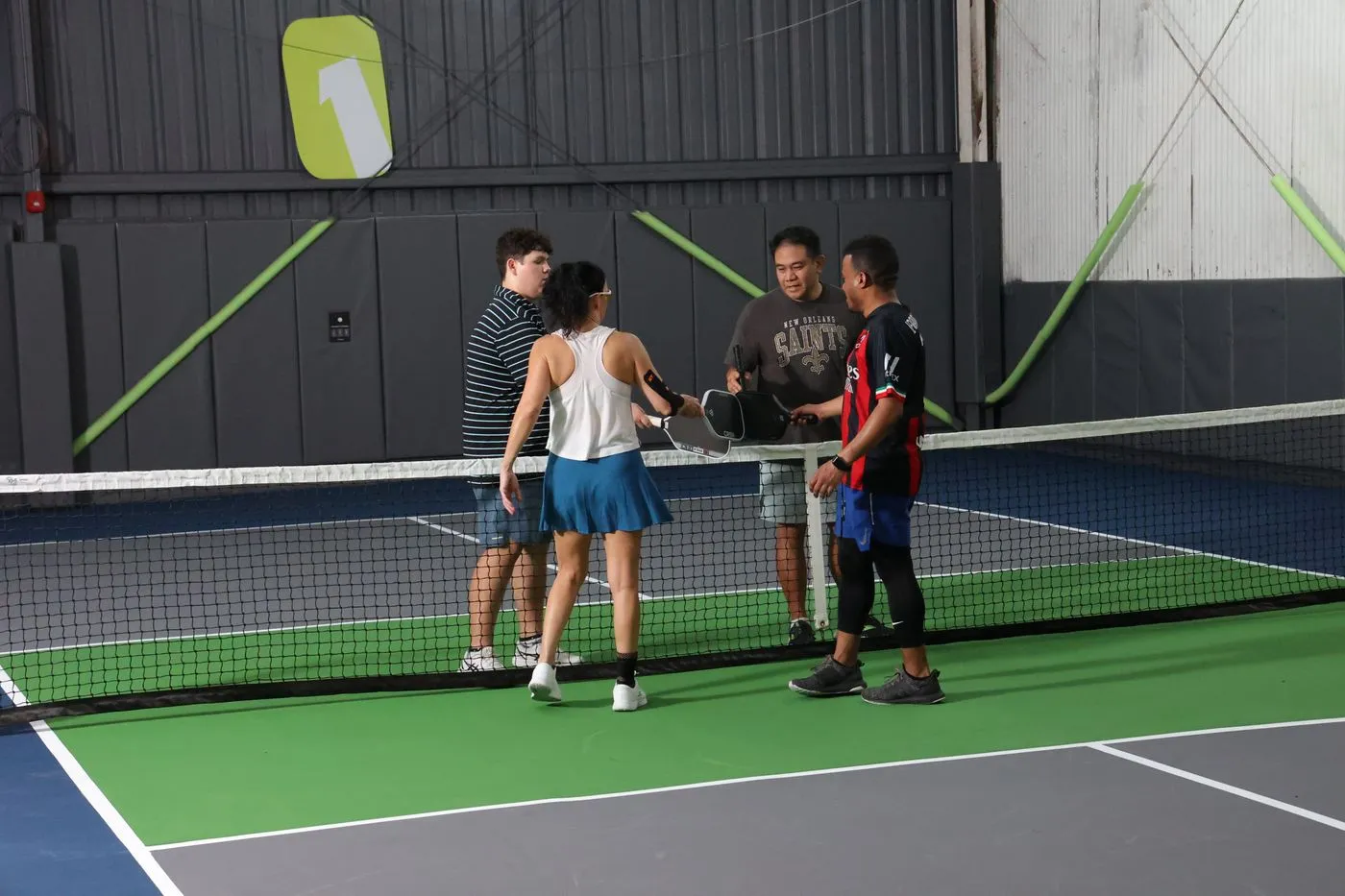 Pickleball players meeting at the net after a game at NOLA PicklePlex