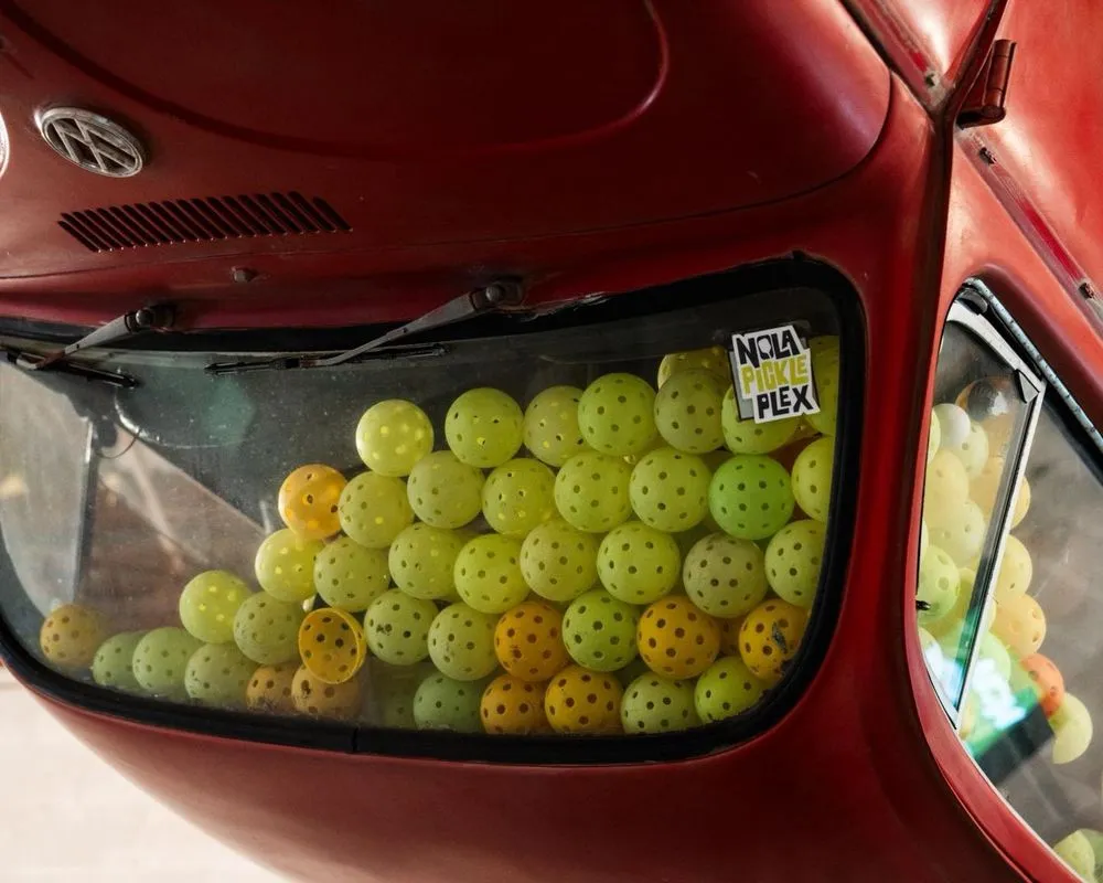 Red car filled with cracked pickleballs at NOLA PicklePlex