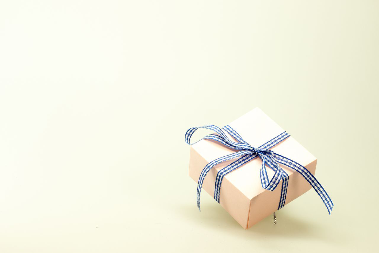 A small gift box tied with a blue gingham ribbon