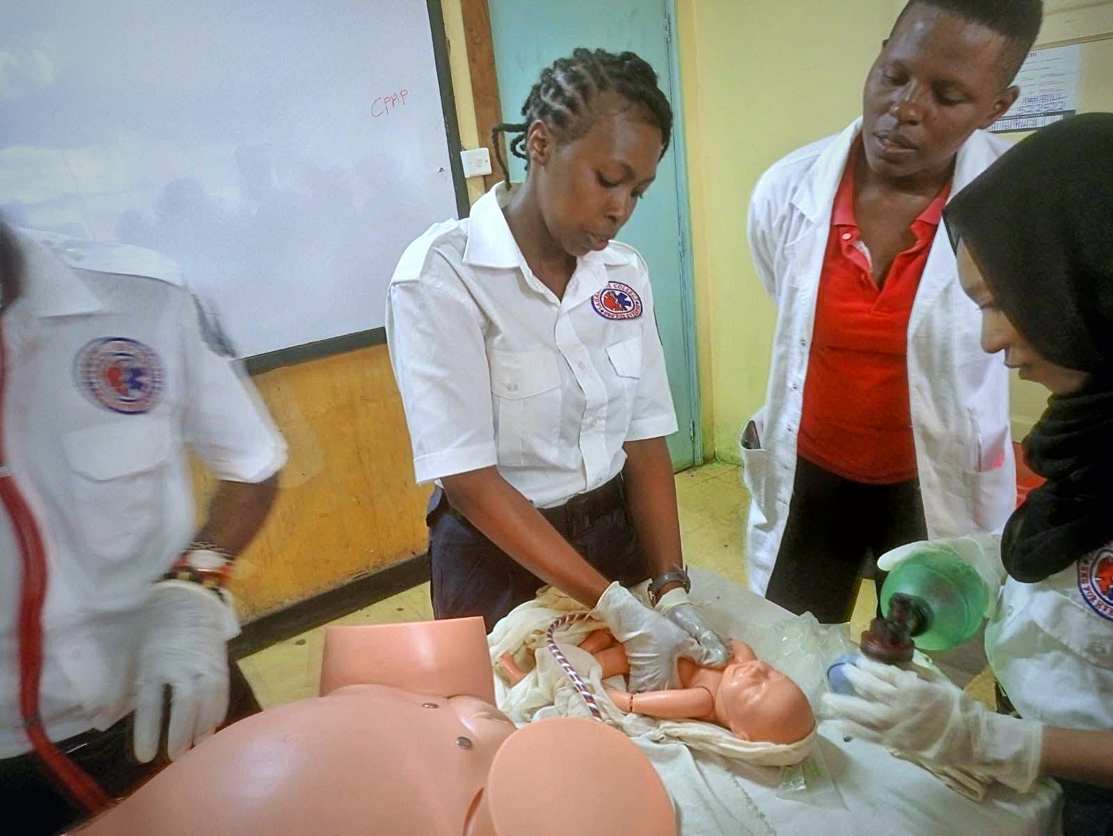 EMT students practising airway management on a manikin