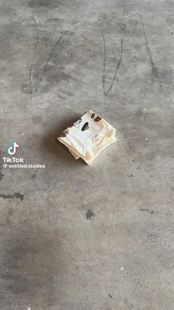 A single sachet lying on a concrete floor, shot from above
