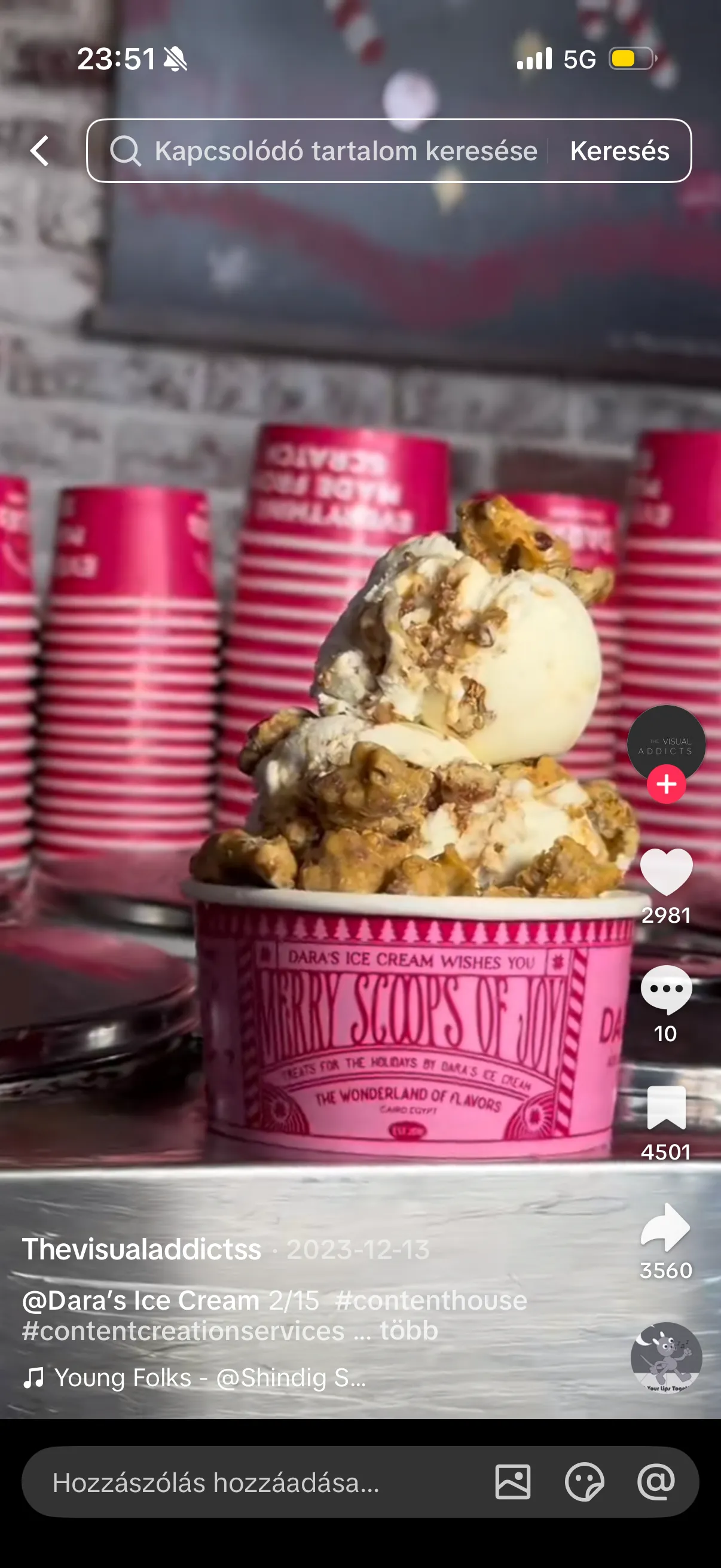 A tall ice cream sundae with stacked pink cups behind it