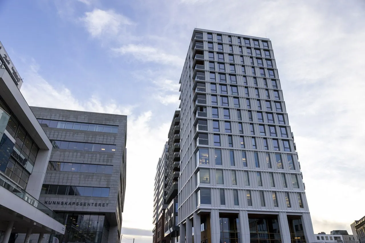 Moderne høyblokk og næringsbygg med glassfasader i bymiljø