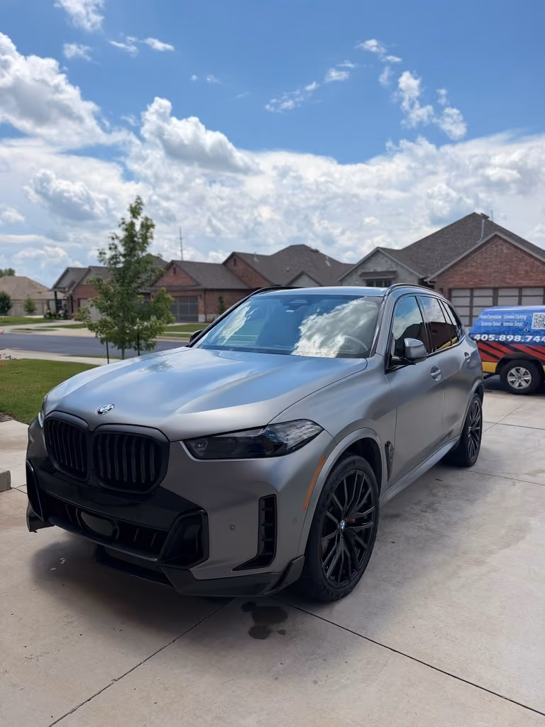 BMW X5 after a monthly maintenance car detail in NW Oklahoma City, with the Champion Detailing truck behind it