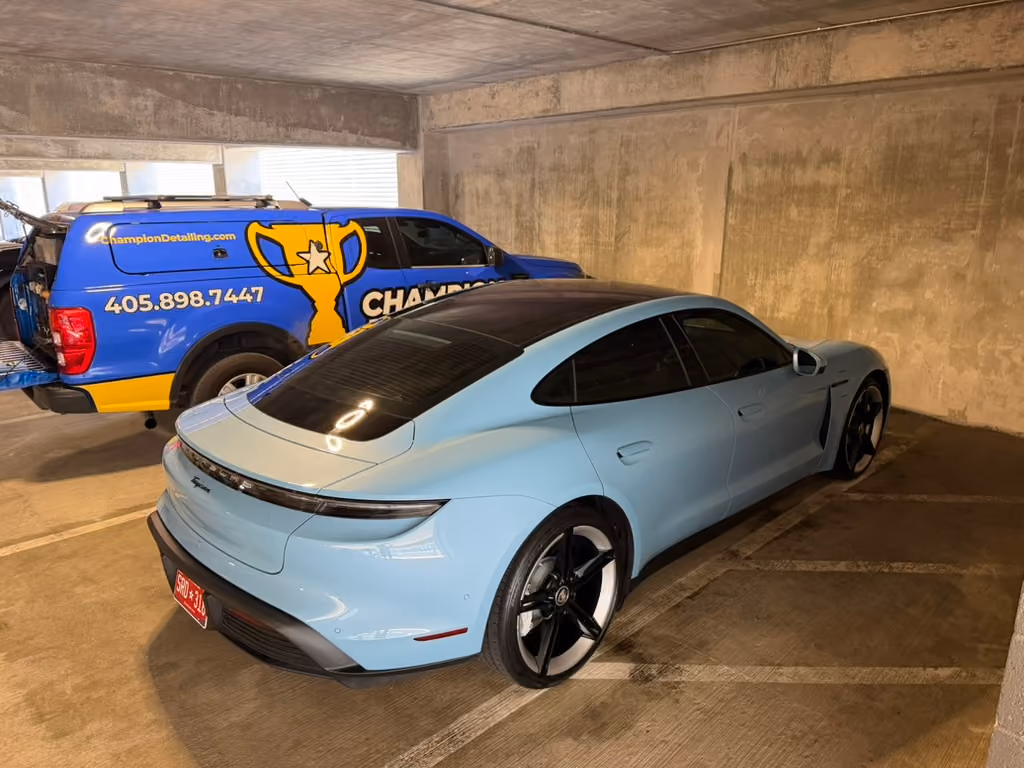 Porsche Taycan after mobile car detailing in Oklahoma City, with the Champion Detailing truck behind it