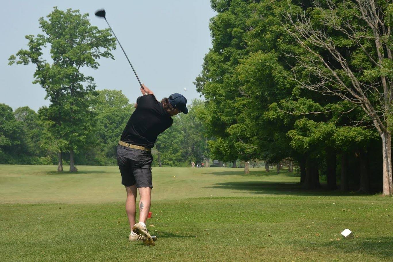 Golfer mid-swing on the fairway