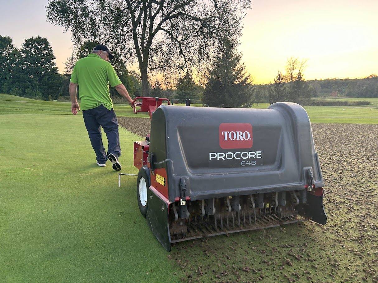Greens crew caring for the course at dusk