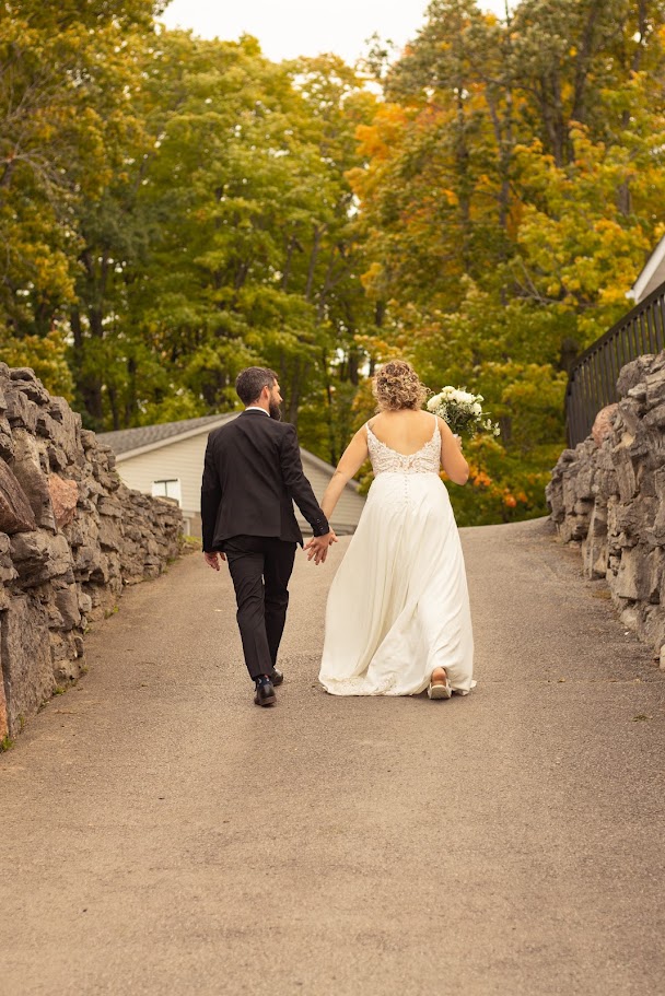 Bride and groom walking hand in hand up the stone path