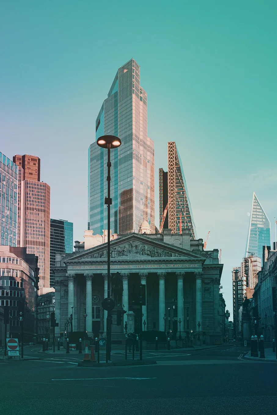 A classical bank building among modern towers in a financial district