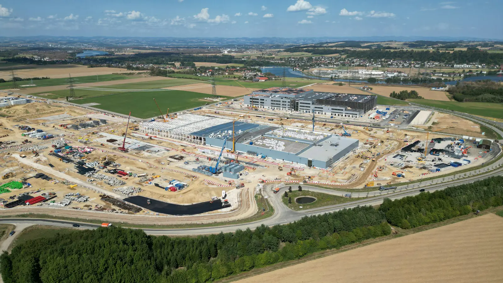 Aerial view of a large industrial construction site with structures and access roads.