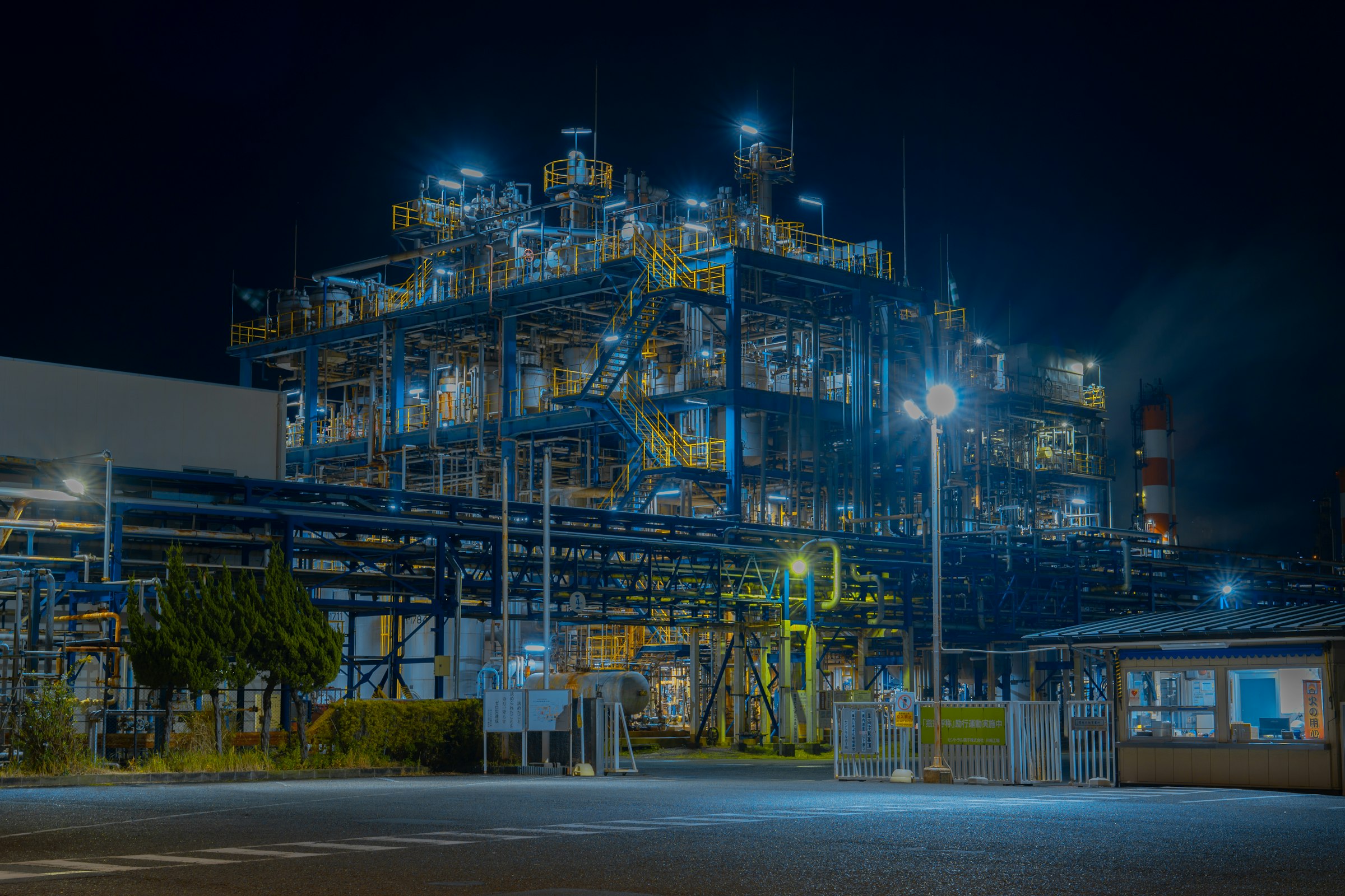 An industrial processing facility lit up at night, with steel structures, pipework and walkways.