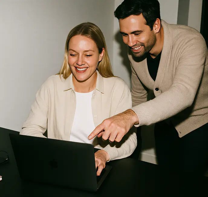 Recruiter and candidate reviewing a job offer together on a laptop