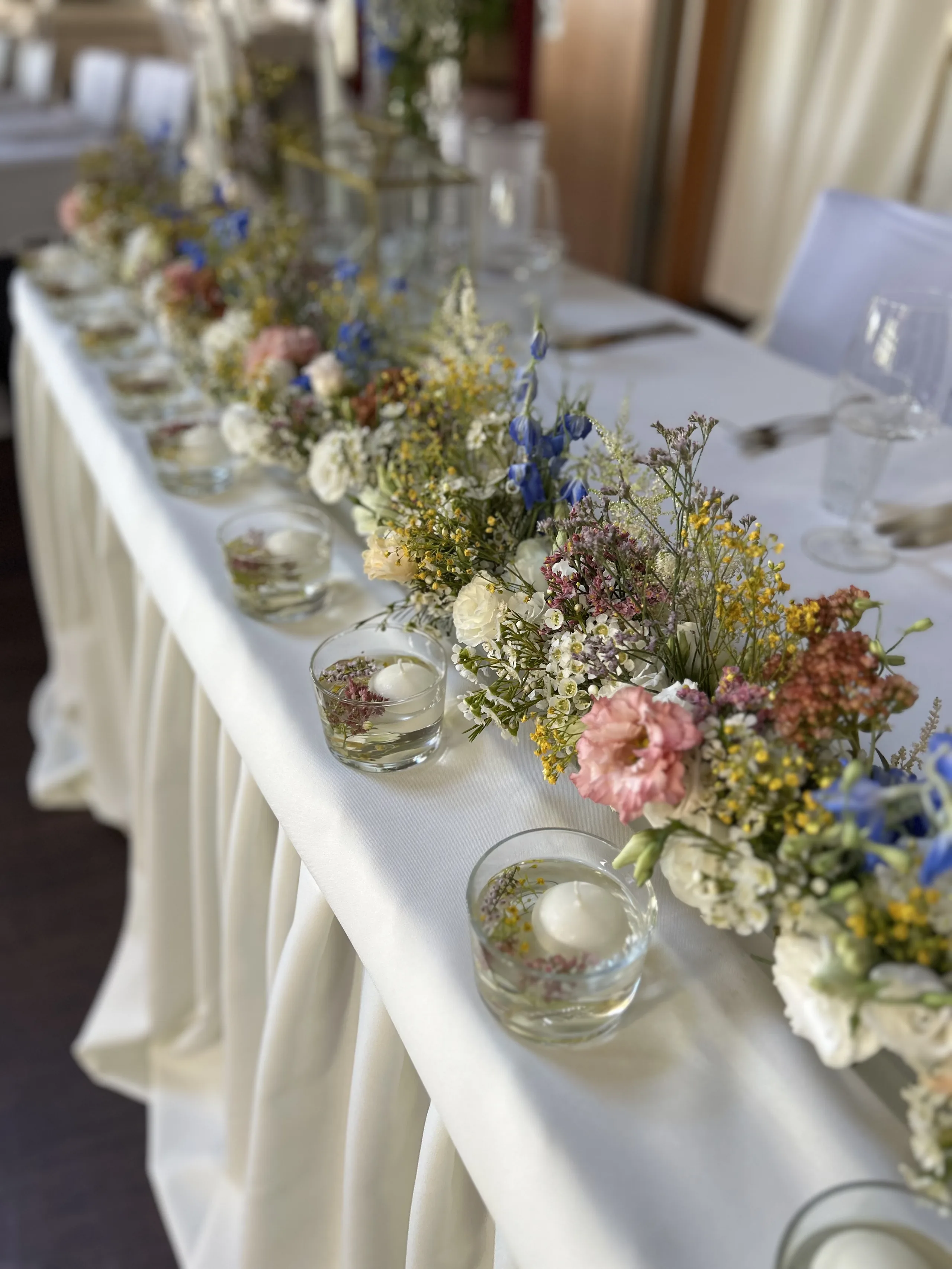 Traubogen mit weißen Tüchern und Blumen auf der Seewiese, im Hintergrund der See
