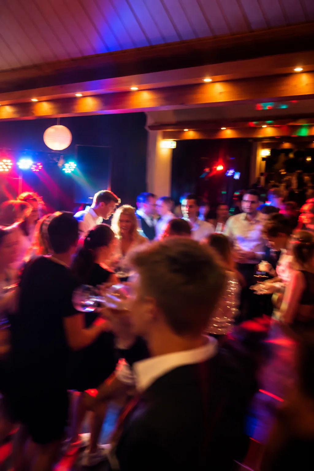 Feiernde Gäste unter bunten Partylichtern
