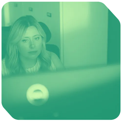a woman sitting in a chair looking at a computer screen