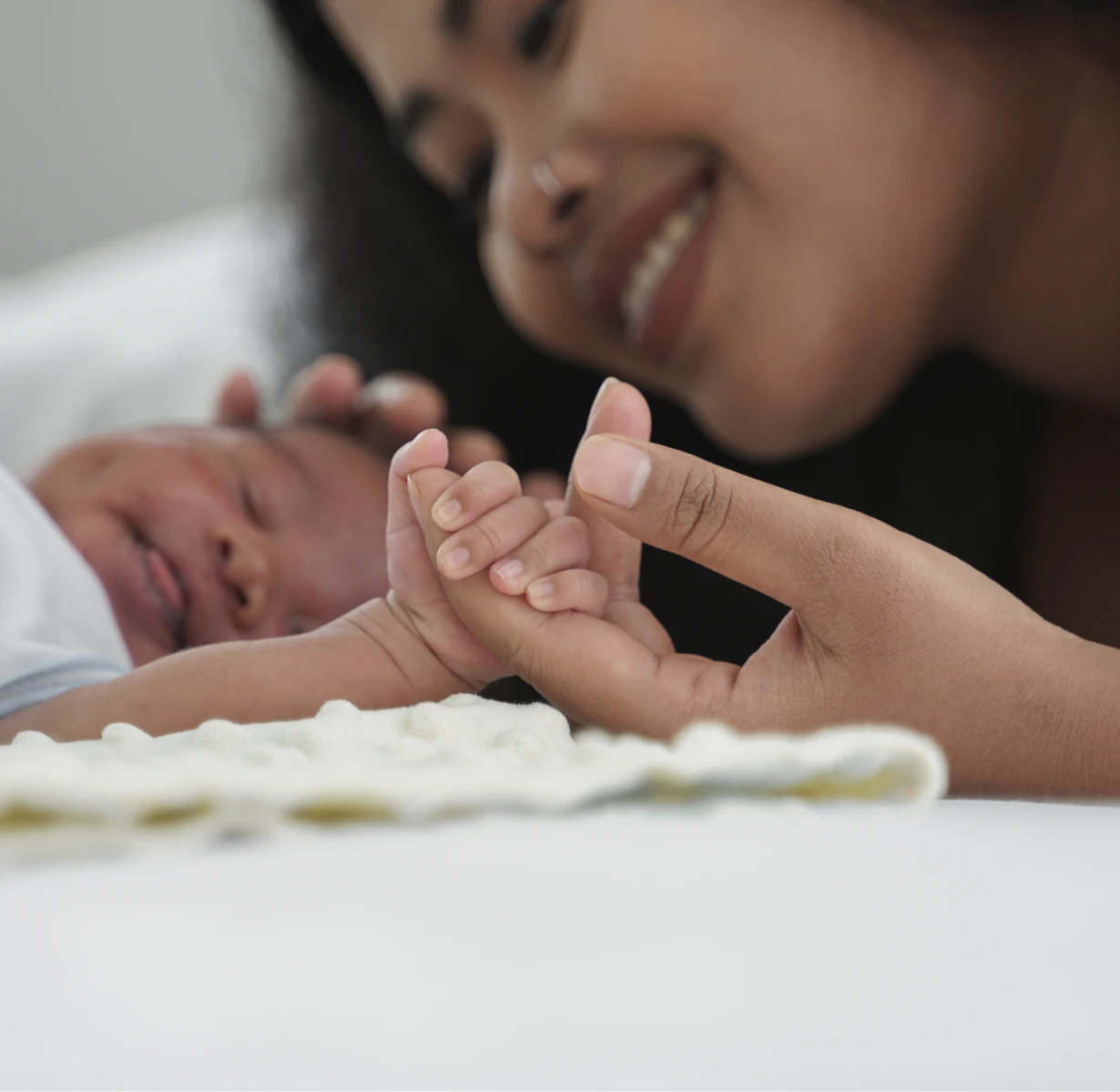 a mother holding her babies hand