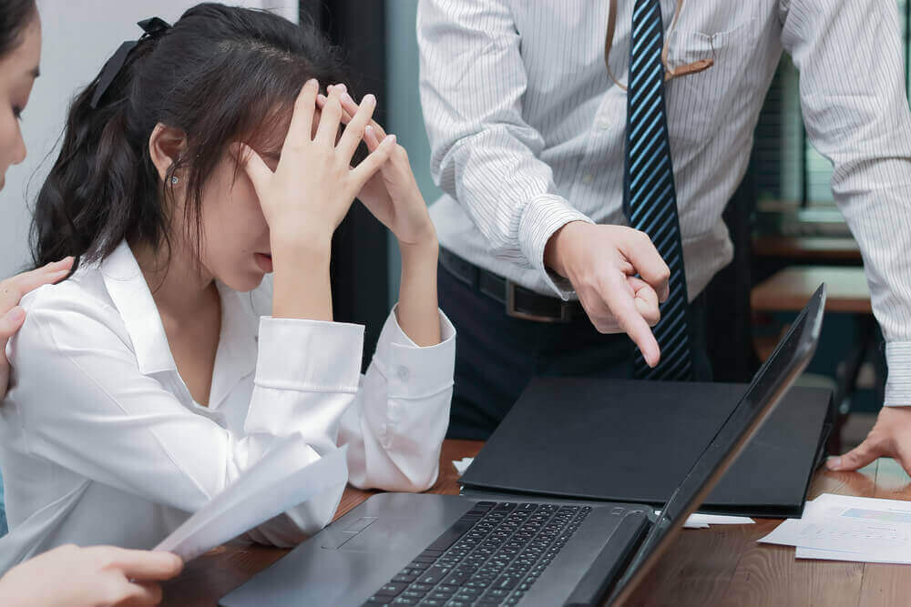 An intern talking with a colleague about a work task in an office