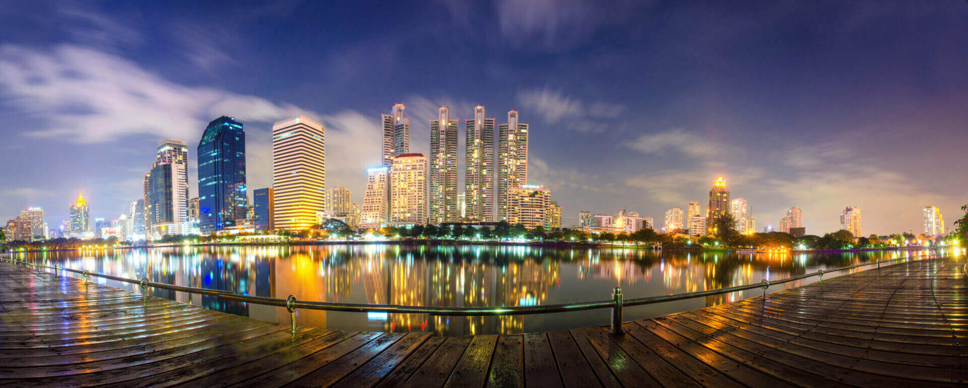 Bangkok skyline lit up at dusk and reflected in the water