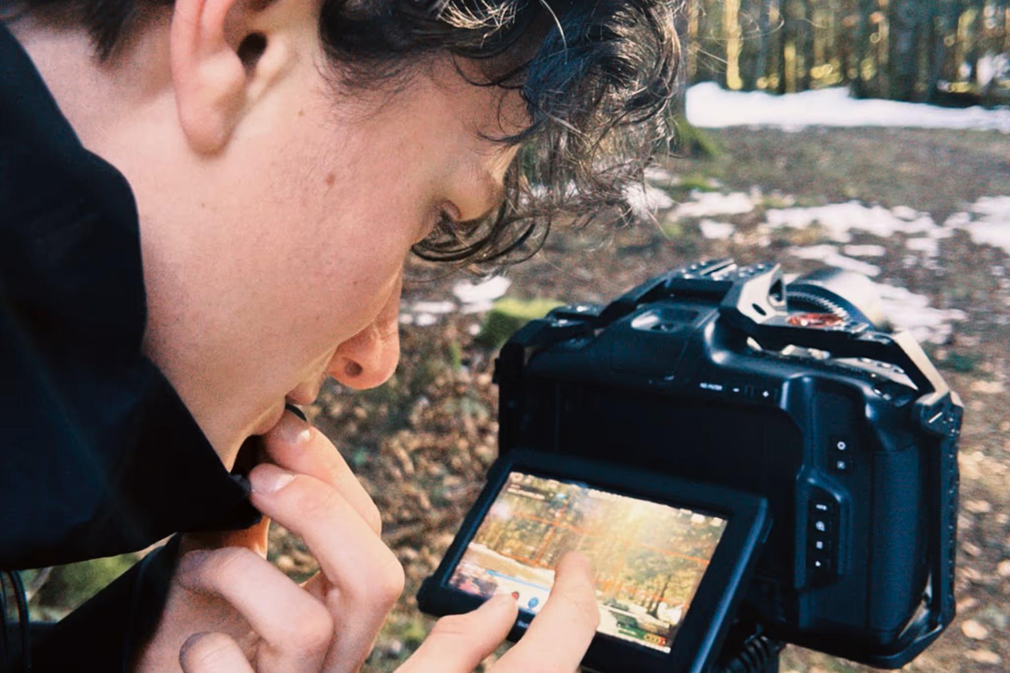 Samuel Bauchet-Faucouneau on a shoot, checking a shot on his camera screen in a forest