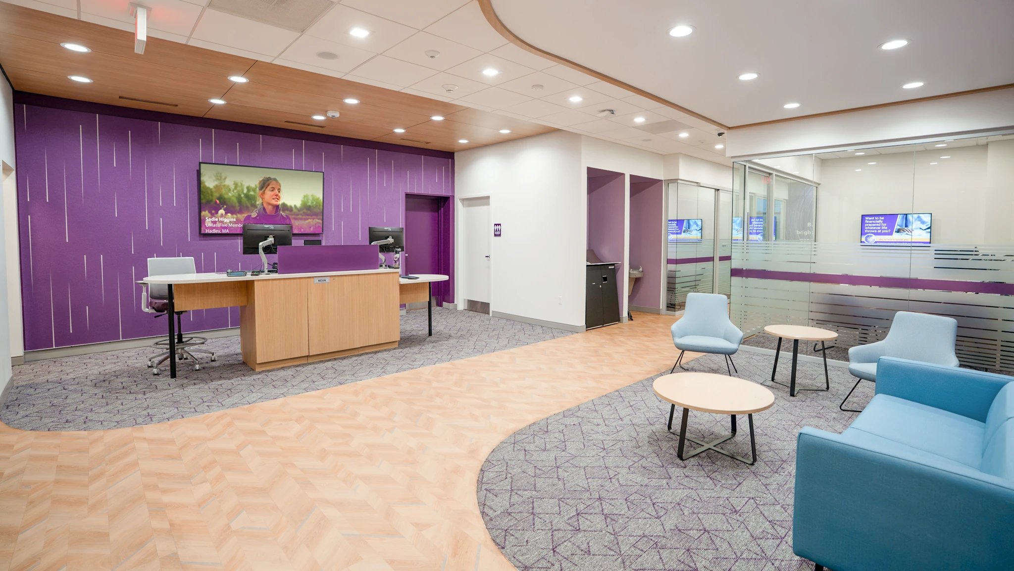 UMassFive branch lobby with purple digital focal wall, teller station, and lounge seating