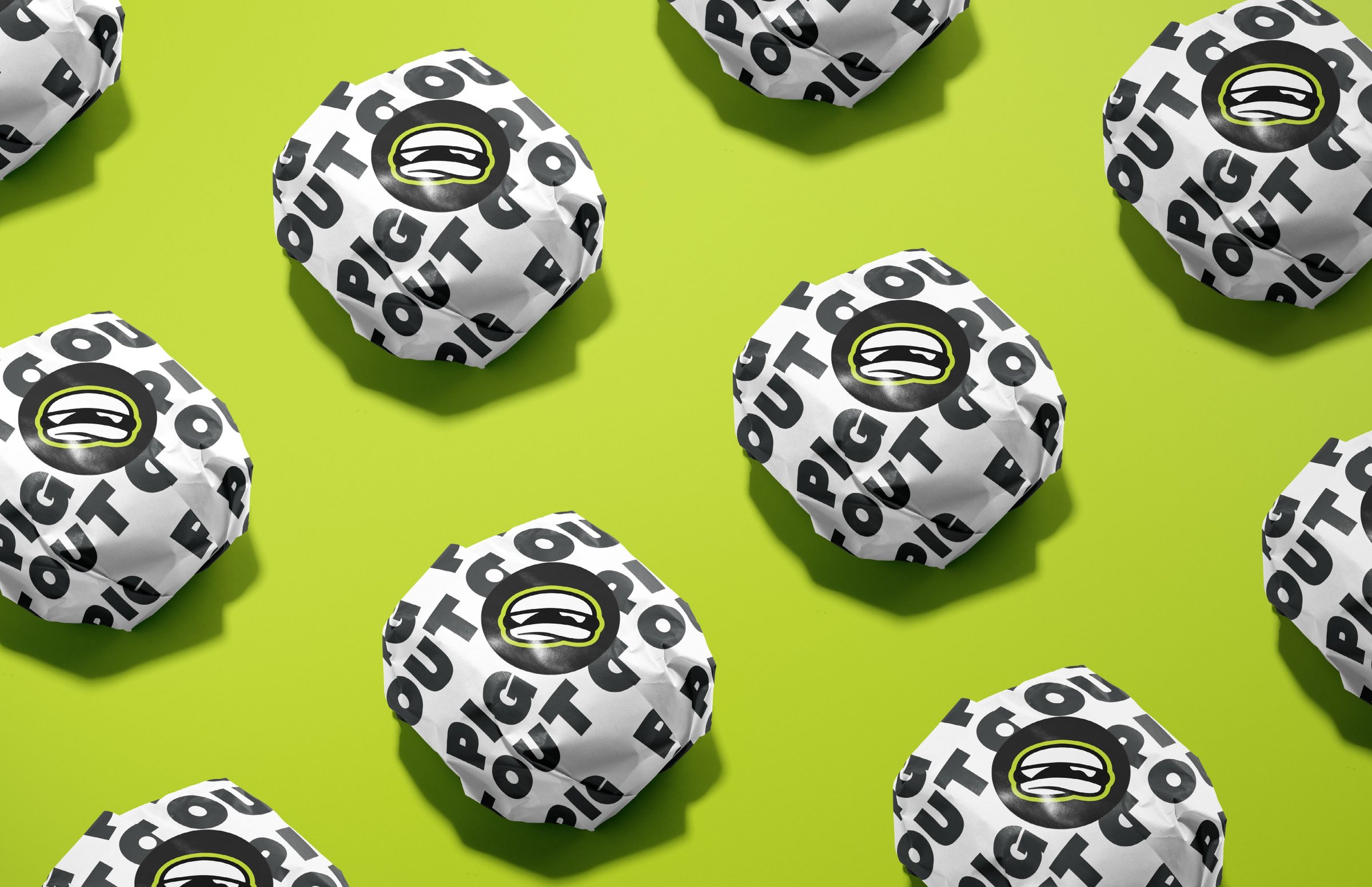Rows of Pig Out branded burger wraps on a green background