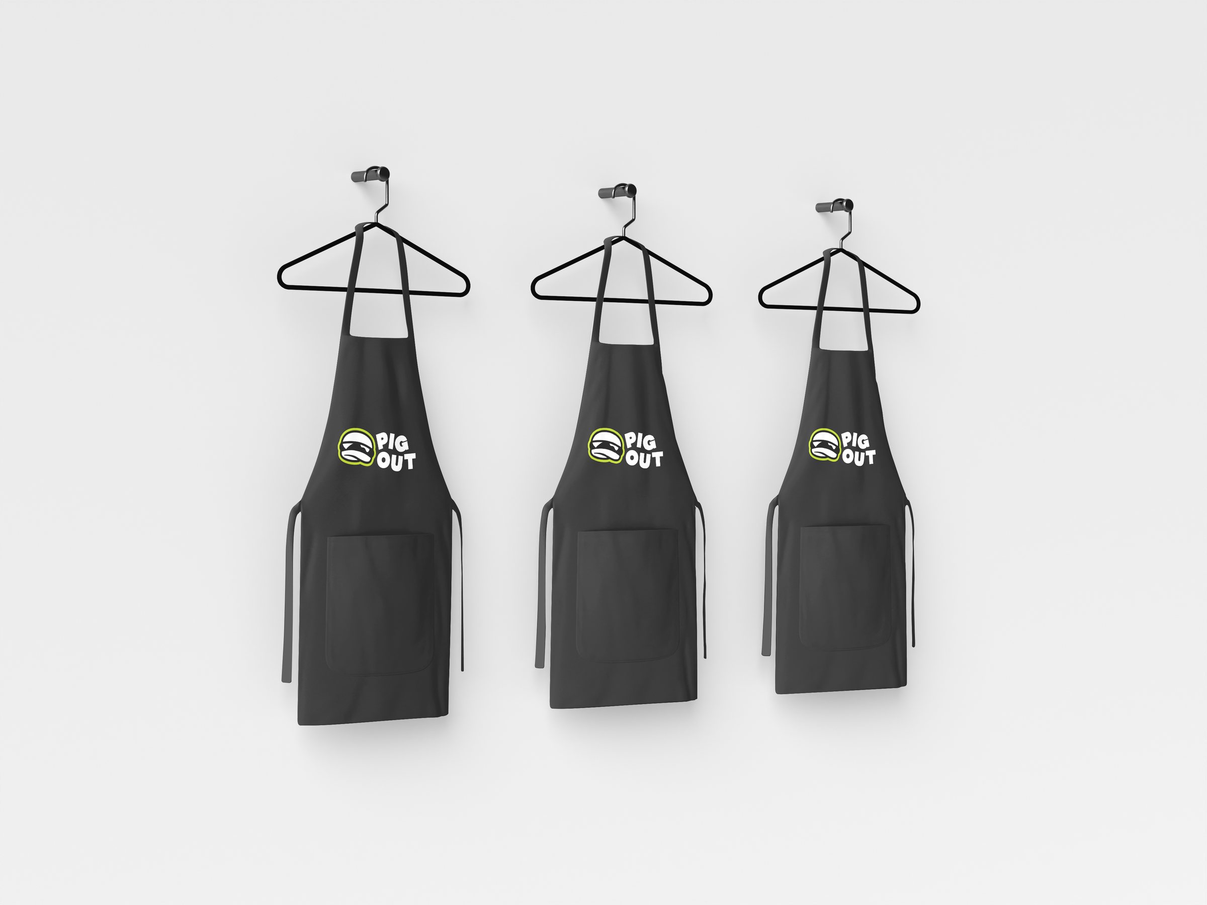 Black Pig Out staff aprons on hangers