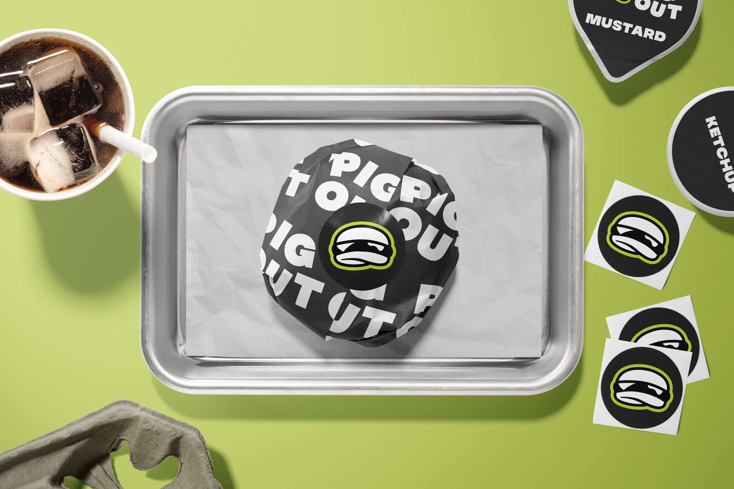 Pig Out branded burger wrap on a tray with condiment stickers